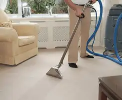 Carpet cleaning professional removing dirt and stains with a hot-water extraction tool in a home, Las Vegas, NV.