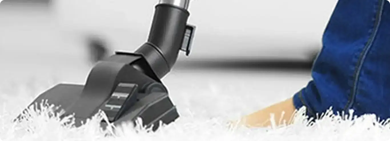 Close-up of a professional vacuuming a white carpet in North Las Vegas.