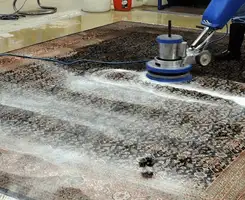 Professional rug cleaning with a rotary floor machine and shampoo foam, deep-cleaning an area rug, in Las Vegas, NV.